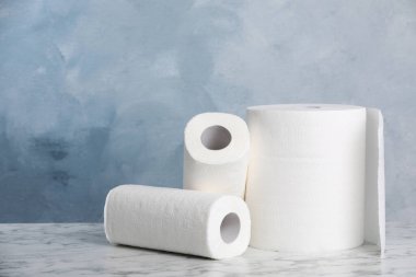 Rolls of paper towels on white marble table. Space for text