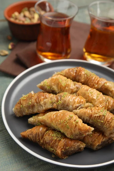 Pyszna Baklawa Pistacjami Gorącą Herbatą Jasnoniebieskim Drewnianym Stole — Zdjęcie stockowe