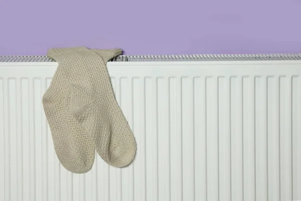Beige Socks Heating Radiator Violet Wall — Stock Photo, Image