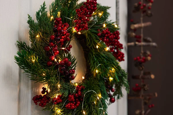 Kırmızı Böğürtlenli Güzel Noel Çelengi Beyaz Kapıya Asılı Peri Işıkları — Stok fotoğraf