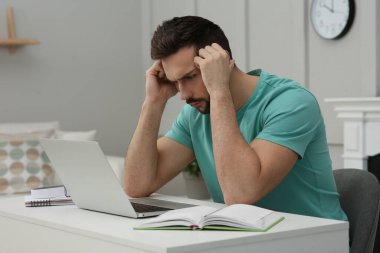 Çevrimiçi test. Evde dizüstü bilgisayarla çalışan bir adam