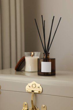 Aromatik kamış oda spreyi ve bavulda mum.