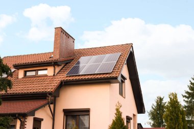Çatıda güneş panelleri olan bir ev. Alternatif enerji