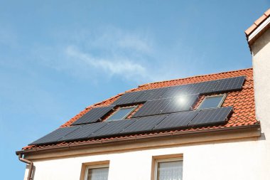 Çatıda güneş panelleri olan bir ev. Alternatif enerji
