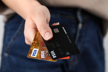 MYKOLAIV, UKRAINE - FEBRUARY 22, 2022: Woman holding Visa credit cards, closeup
