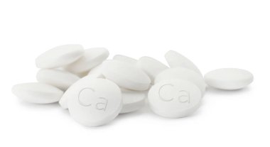 Beyaz arka planda kalsiyum takviyesi hapları yığını