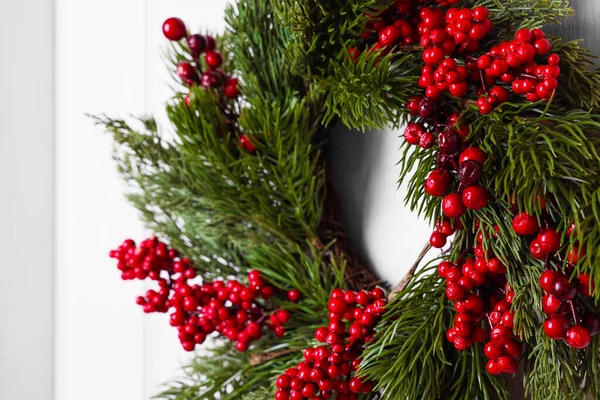 Όμορφο Χριστουγεννιάτικο Στεφάνι Κόκκινα Μούρα Κρέμεται Λευκή Πόρτα Closeup — Φωτογραφία Αρχείου
