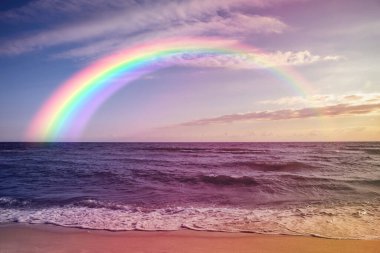 Beautiful view of colorful rainbow in sky over sea