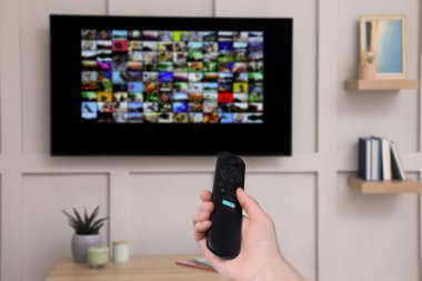 Uzaktan kumandalı kadın evde televizyon izlerken kanal değiştiriyor, kapatıyor