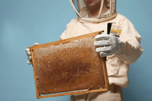 Beekeeper Uniform Holding Hive Frame Honeycomb Tools Light Blue Background — стоковое фото