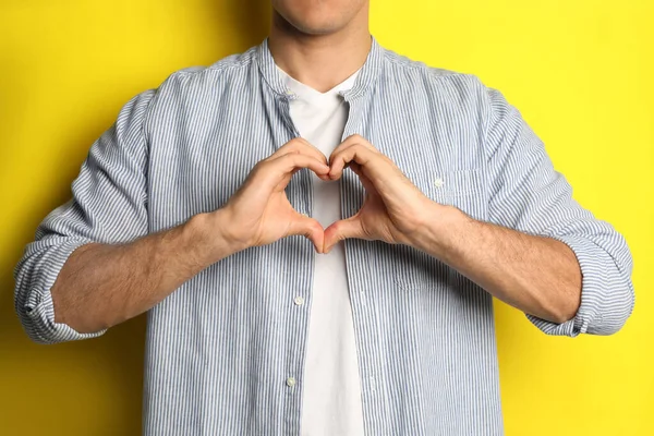 Man Making Heart Hands Yellow Background Closeup — Zdjęcie stockowe