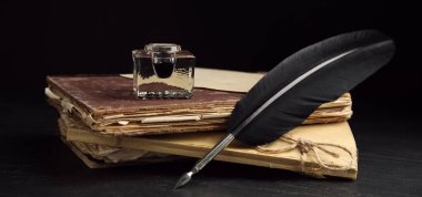 Quill, mürekkep hokkası ve eski kitaplar siyah masanın üzerinde. Pankart tasarımı