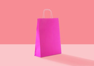 Pink paper bag on color background. Mockup for design