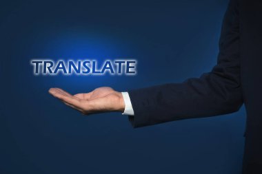 Koyu mavi arkaplana karşı TRANSLATE kelimesinin sanal modelini gösteren adam, yakın plan