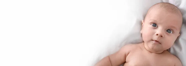 침대에 귀여운 아기가 텍스트를 바라보고 있습니다 — 스톡 사진