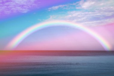 Beautiful view of colorful rainbow in sky over sea