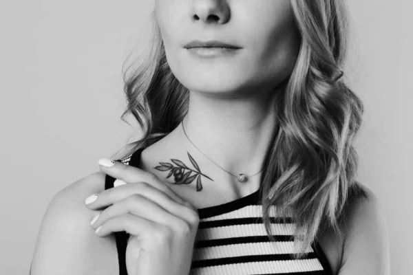 光の背景にタトゥーのある若い女性 クローズアップ 白黒写真 — ストック写真