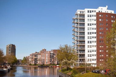 Nehirde modern binalar ve tekneler olan güzel bir şehir manzarası.