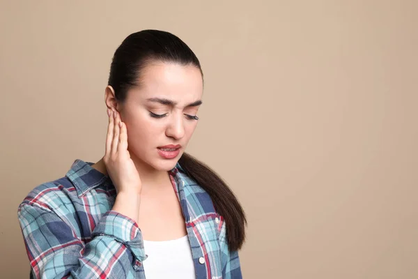 Young Woman Suffering Ear Pain Beige Background Space Text — Stockfoto