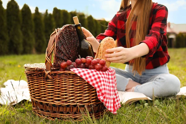 Dışarıdaki piknik sepetinden ekmek alan kız, yakın plan.