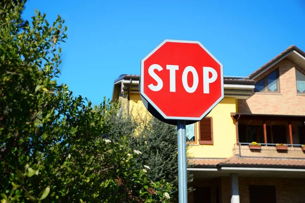 Traffic sign STOP near house on sunny day