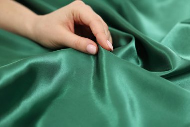 Yumuşak ipek kumaşa dokunan kadın, yakın çekim görüntüsü.