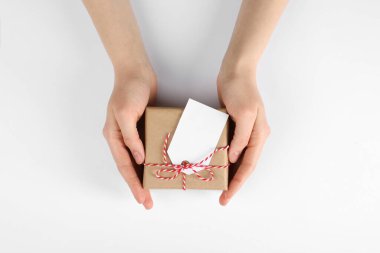 Beyaz arkaplanda etiketli bir pakete sarılı kadın, üst görünüm