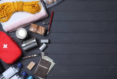 Earthquake supply kit on black wooden table, flat lay. Space for text