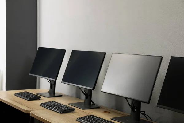 Open Kantoorinterieur Moderne Werkplekken Met Computers Bij Lichtgrijze Wand — Stockfoto