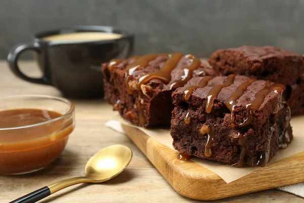Delicious Chocolate Brownies Nuts Caramel Sauce Wooden Table — Φωτογραφία Αρχείου