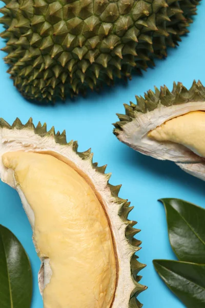 Fresh Ripe Durians Leaves Light Blue Background Flat Lay — Zdjęcie stockowe