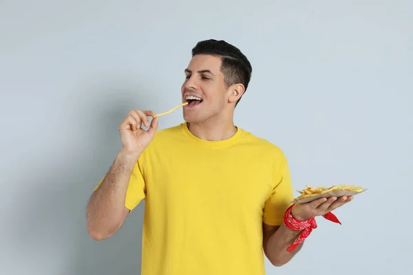 Man Eating French Fries Grey Background — Zdjęcie stockowe