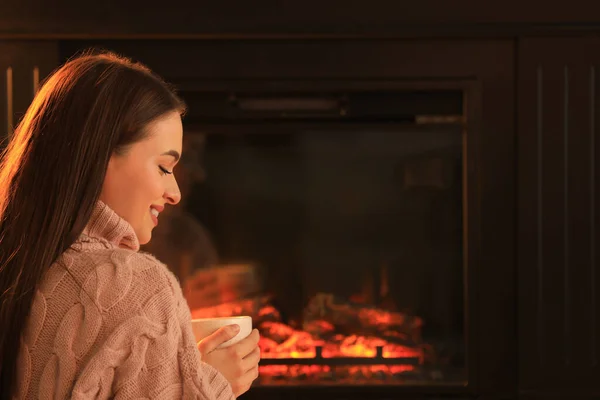Young Woman Cup Hot Drink Fireplace Indoors Cozy Atmosphere — Stock Fotó