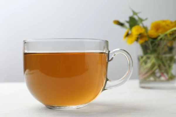 Köstlicher Frischer Tee Und Schöne Löwenzahnblüten Auf Weißem Tisch — Stockfoto