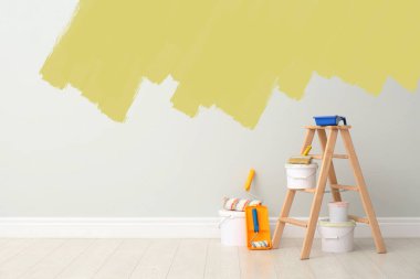 Decorator's kit of tools and paints near wall indoors