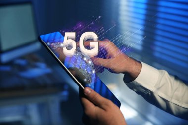 Kapalı alanda 5G ağ sistemi olan tablet kullanan adam, kapat