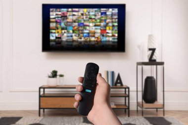 Uzaktan kumandalı kadın evde televizyon izlerken kanal değiştiriyor, kapatıyor