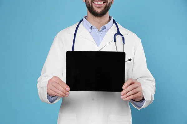 Açık Mavi Arka Planda Steteskoplu Boş Tabletli Doktorun Yakın Görüntüsü — Stok fotoğraf