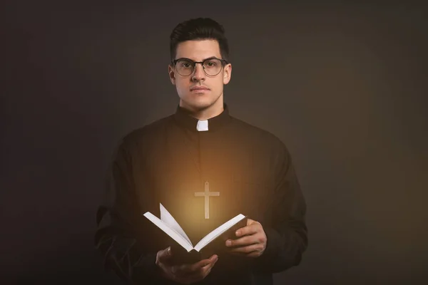 Priest Cassock Holding Bible Holy Light Black Background — Zdjęcie stockowe