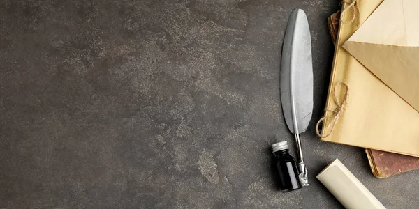 Düz kompozisyon, tüy kalemi ve bir şişe mürekkeple gri masa, yazı için boşluk. Pankart tasarımı