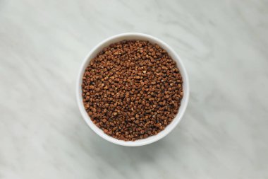 Beyaz mermer masa üzerinde pişmemiş karabuğday lapası, üst manzara.