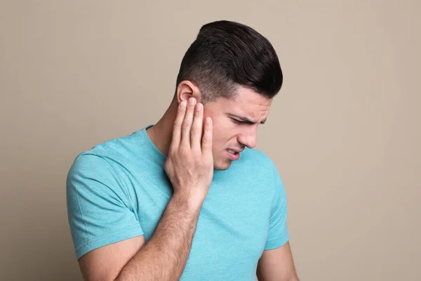 Homme Souffrant Douleur Oreille Sur Fond Beige — Photo