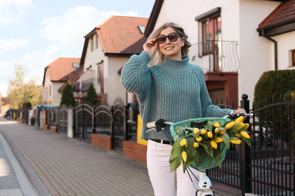 Bisikletli ve sarı laleli güzel bir kadın.