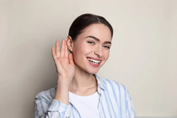 Junge Frau Zeigt Hand Ohr Geste Auf Hellem Hintergrund — Stockfoto