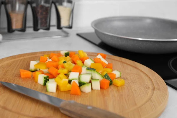 야채와 도마를 주방에서 프라이팬 가까이에 뚜껑을 덮는다 — 스톡 사진