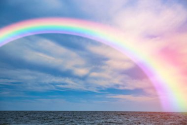 Beautiful view of colorful rainbow in sky over sea