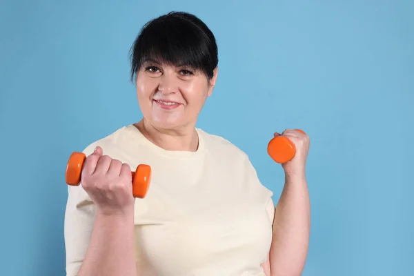 Happy Overweight Mature Woman Doing Exercise Dumbbells Light Blue Background — стоковое фото