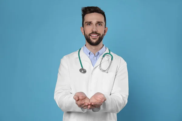Steteskoplu Doktor Açık Mavi Arka Planda Bir Şey Tutuyor Kardiyoloji — Stok fotoğraf