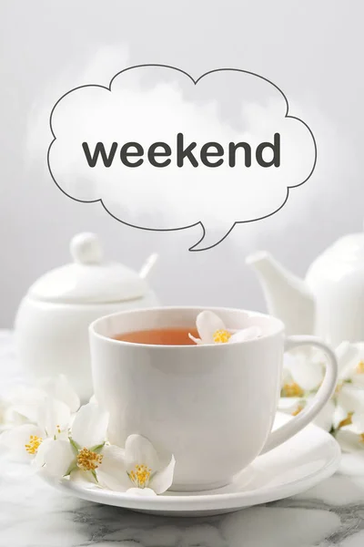 Happy Weekend. Aromatic jasmine tea and fresh flowers on white marble table