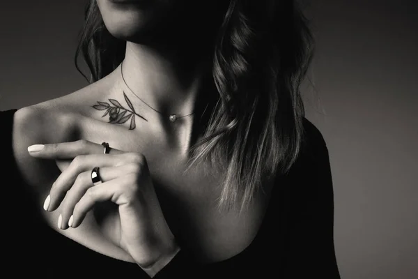 暗い背景にタトゥーのある若い女性 クローズアップ 白黒写真 — ストック写真